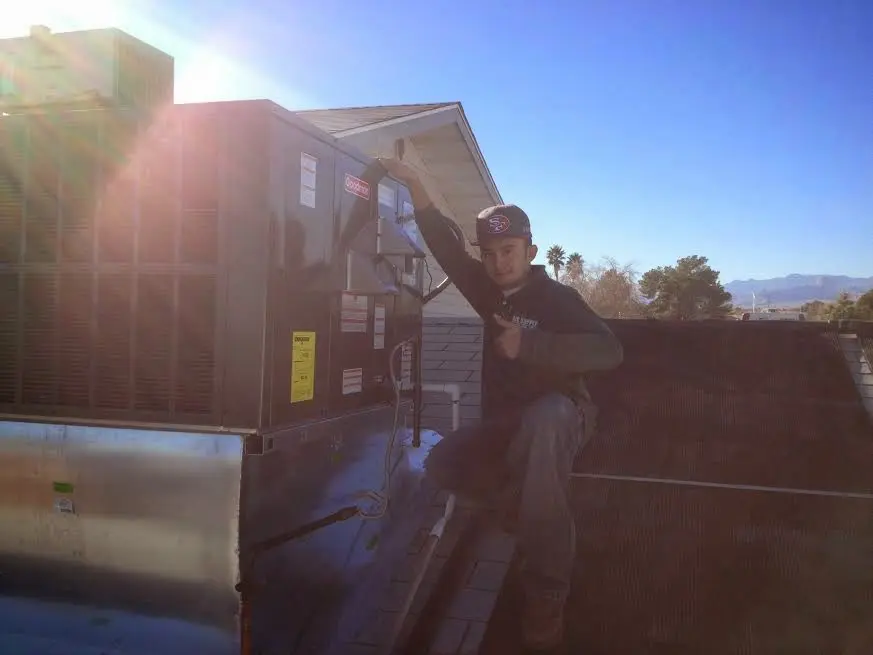 HVAC technician performing AC Tune-Up on a rooftop unit in San Elizario